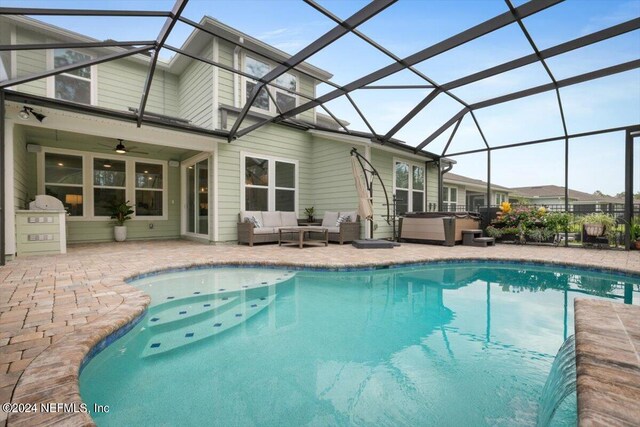 view of swimming pool with outdoor lounge area, ceiling fan, a patio area, and a lanai