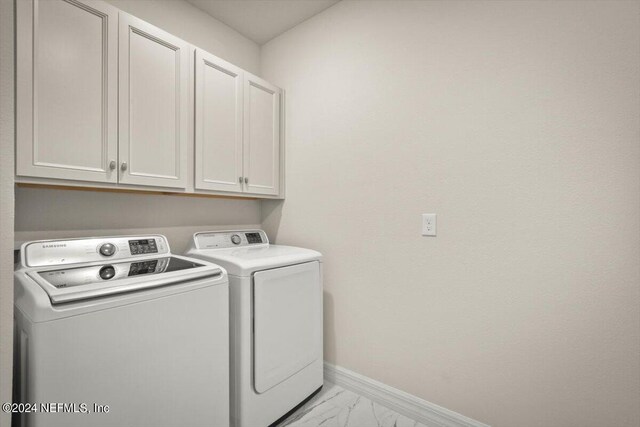 laundry room featuring cabinets and washer and dryer