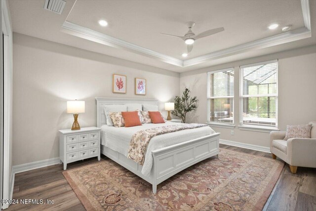 bedroom featuring ceiling fan, hardwood / wood-style floors, and a raised ceiling