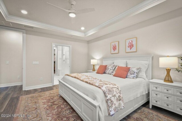 bedroom featuring dark wood-type flooring, ornamental molding, ensuite bathroom, and ceiling fan