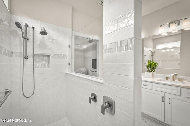 bathroom with vanity and tiled shower