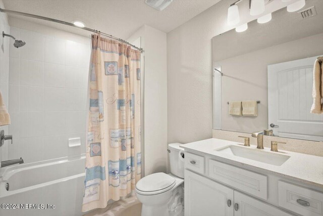 full bathroom with vanity, toilet, and shower / tub combo with curtain