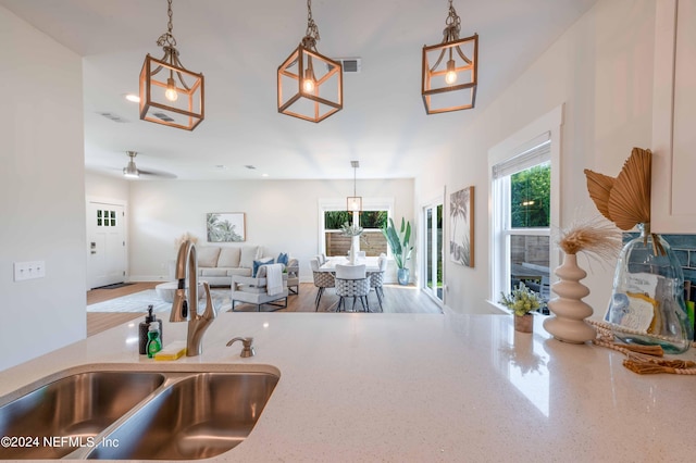 6833 A Ave, Saint Augustine, FL 32080 - kitchen with a sink, decorative light fixtures, light stone countertops, and open floor plan