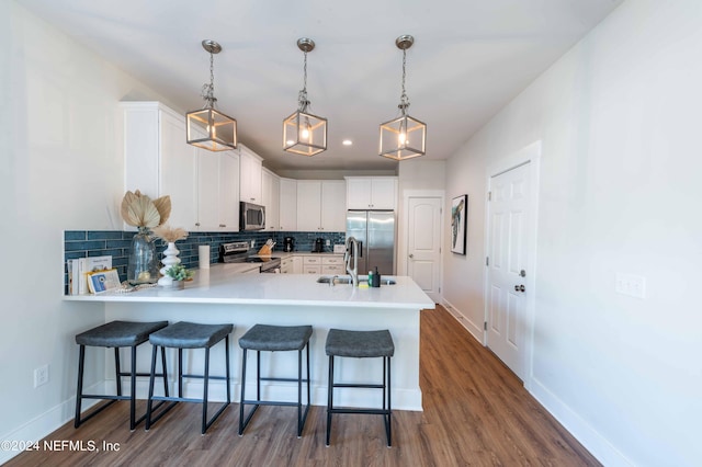 6833 A Ave, Saint Augustine, FL 32080 - kitchen featuring appliances with stainless steel finishes, a peninsula, backsplash, dark wood-style flooring, and baseboards