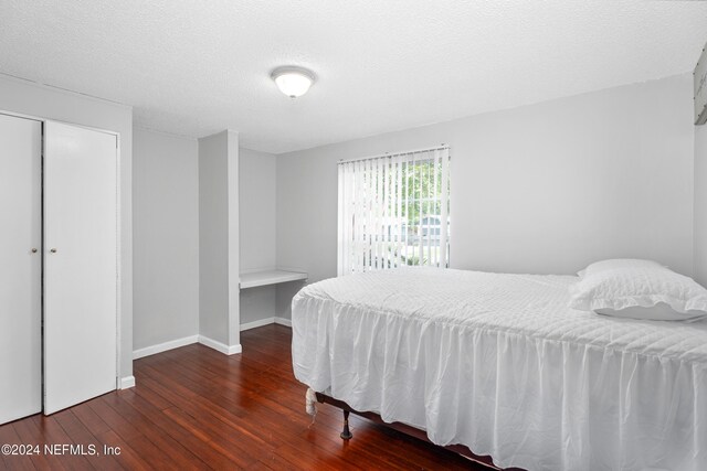 bedroom featuring a textured ceiling, a closet, and hardwood / wood-style floors