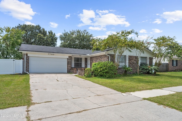 single story home featuring a garage and a front lawn