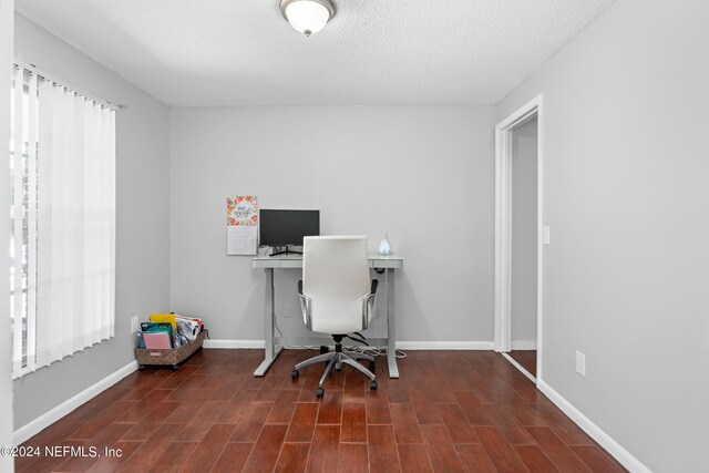 home office with hardwood / wood-style floors, a wealth of natural light, and a textured ceiling