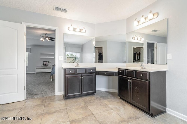 bathroom featuring tile patterned flooring, vanity, ceiling fan, and a textured ceiling