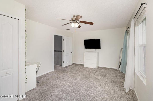 unfurnished bedroom featuring carpet, a textured ceiling, and baseboards