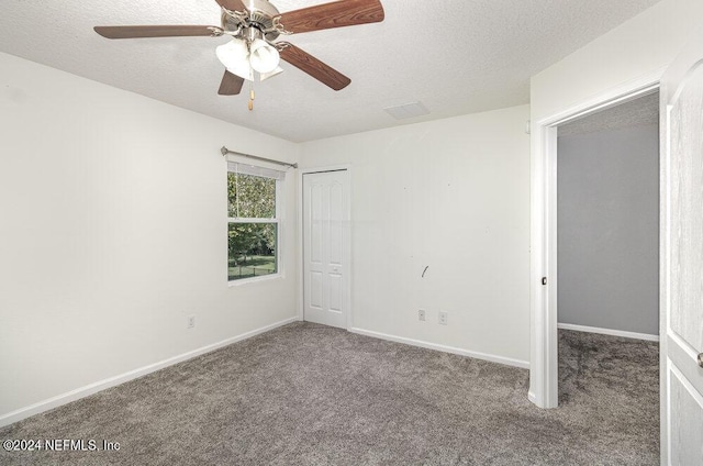 carpeted spare room with ceiling fan, a textured ceiling, and baseboards