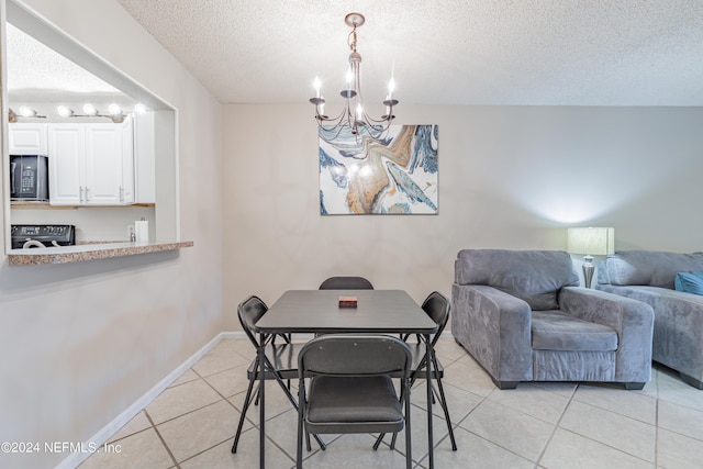 dining space with light tile patterned flooring, an inviting chandelier, and a textured ceiling