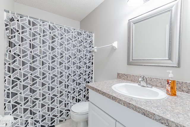 bathroom with vanity, walk in shower, a textured ceiling, and toilet