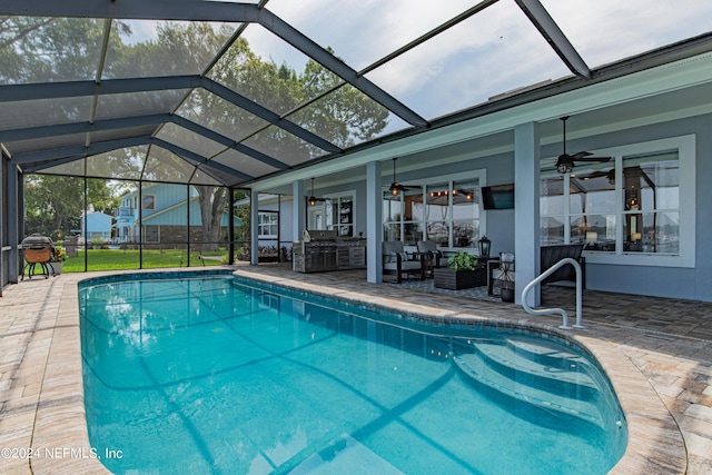 outdoor pool featuring a patio area, glass enclosure, an outdoor hangout area, and a ceiling fan