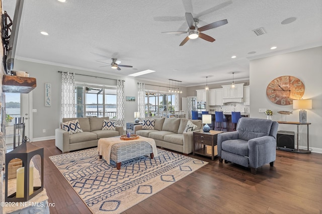 living room with ornamental molding, dark wood-style flooring, visible vents, and a textured ceiling