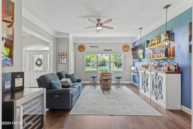 living room with a bar, wine cooler, a wealth of natural light, and wood finished floors