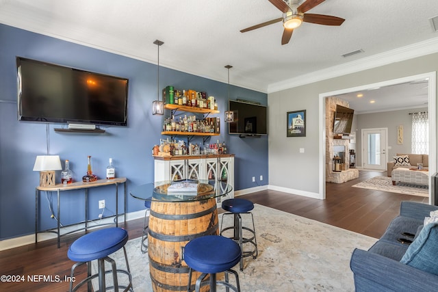 bar featuring wood finished floors, visible vents, baseboards, a dry bar, and crown molding