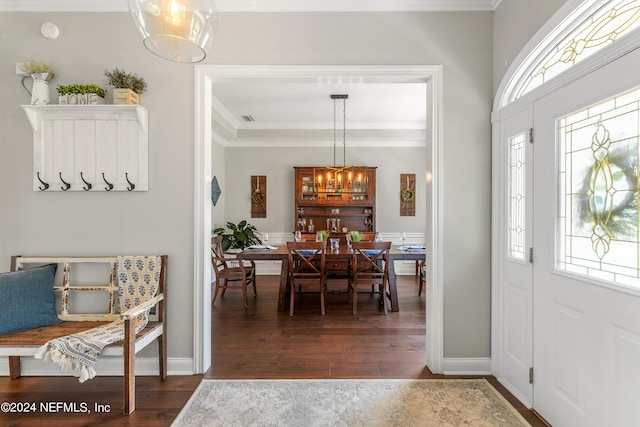 foyer entrance with baseboards, ornamental molding, dark wood finished floors, and a notable chandelier