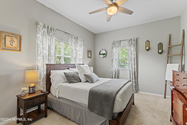 bedroom featuring a ceiling fan, light colored carpet, and baseboards