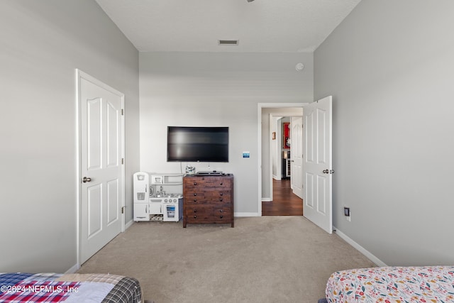 carpeted bedroom with visible vents, a textured ceiling, and baseboards