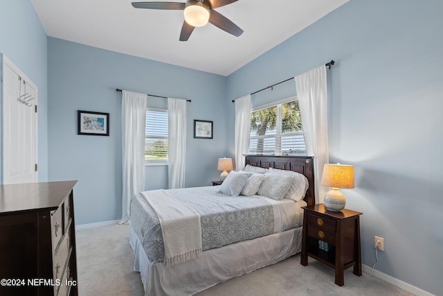 bedroom with baseboards, ceiling fan, and light colored carpet