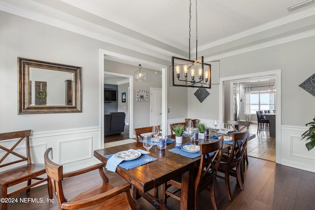 dining room featuring dark wood-style floors, wainscoting, ornamental molding, and visible vents