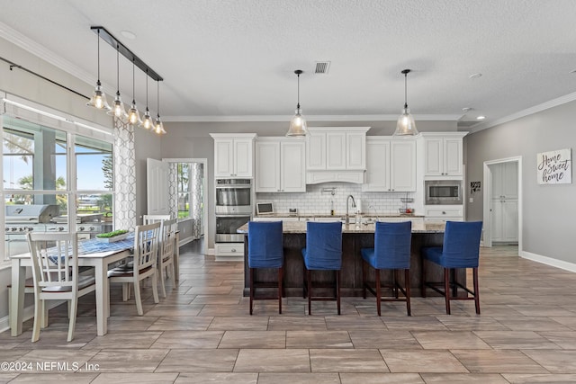 kitchen with white cabinets, appliances with stainless steel finishes, visible vents, and decorative backsplash