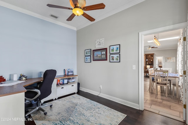 home office featuring a ceiling fan, visible vents, baseboards, ornamental molding, and dark wood-style floors