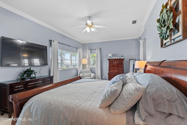 bedroom with visible vents, ornamental molding, a ceiling fan, a textured ceiling, and ornate columns