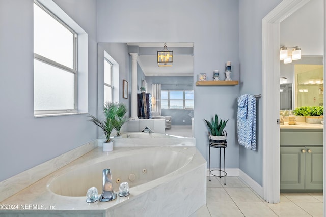 bathroom featuring vanity, a chandelier, tile patterned flooring, a jetted tub, and baseboards