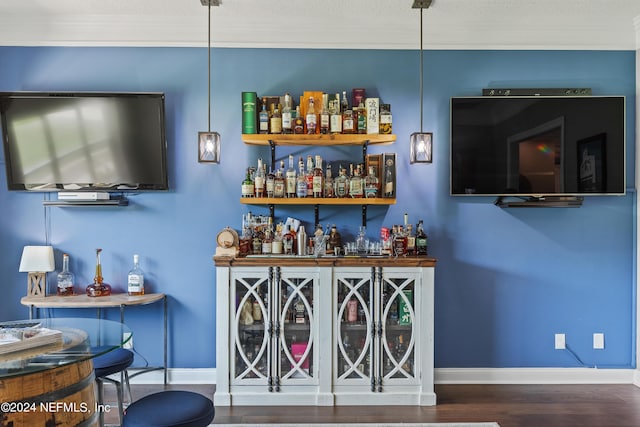 bar with a bar, baseboards, and wood finished floors