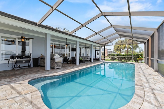 outdoor pool with ceiling fan, glass enclosure, a patio area, and a grill