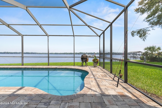 pool with a lanai, a water view, a lawn, and a patio