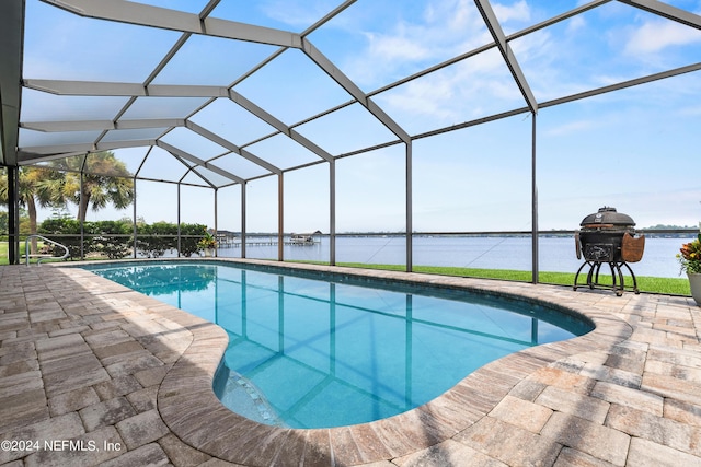 pool featuring a lanai, a water view, and a patio