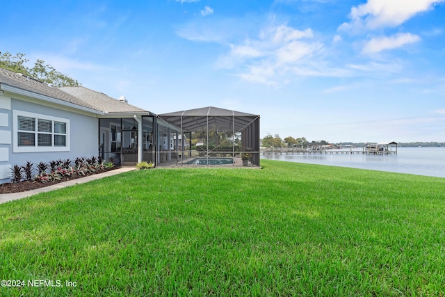 view of yard with glass enclosure and a water view