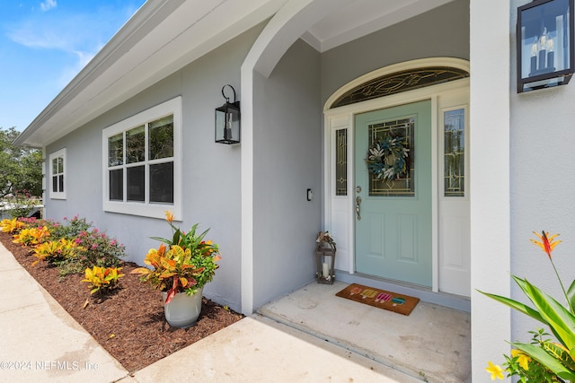 doorway to property featuring stucco siding