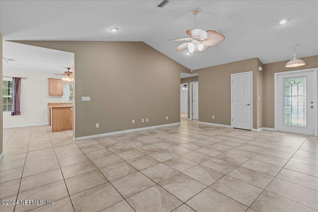 unfurnished living room featuring ceiling fan, lofted ceiling, and light tile patterned flooring