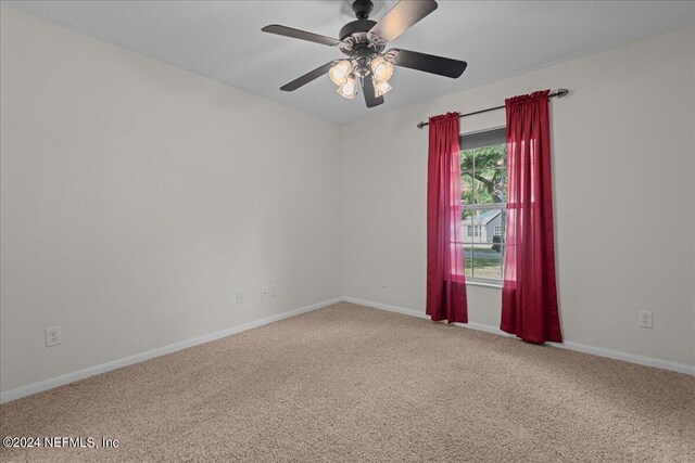 carpeted spare room with ceiling fan