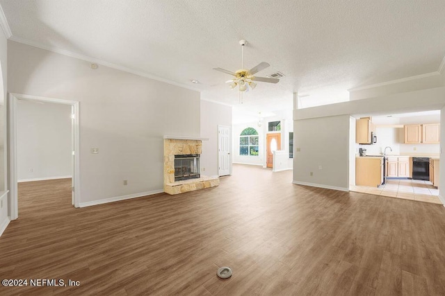 unfurnished living room with visible vents, a fireplace, a textured ceiling, and light wood finished floors