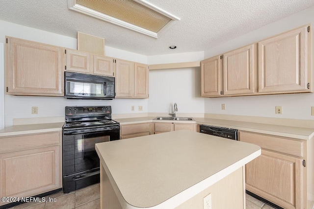 kitchen featuring black appliances, light countertops, a sink, and light brown cabinetry