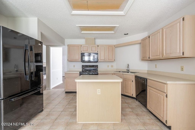 kitchen with light brown cabinets, a sink, light countertops, a center island, and black appliances