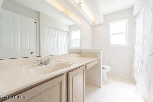 bathroom with tile patterned flooring, toilet, and vanity