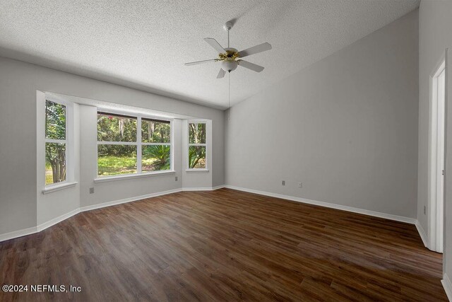 unfurnished room featuring plenty of natural light, lofted ceiling, ceiling fan, and dark wood-type flooring