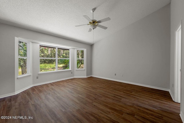 spare room with lofted ceiling, ceiling fan, dark wood finished floors, and a textured ceiling