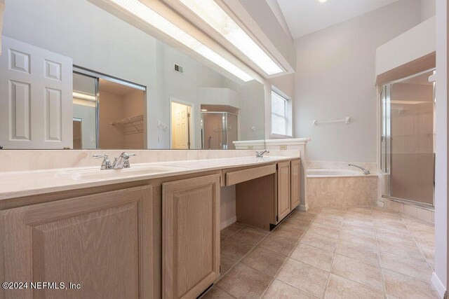 bathroom with lofted ceiling, a sink, a shower stall, and double vanity