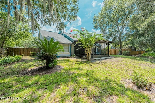 view of yard with a sunroom and a fenced backyard