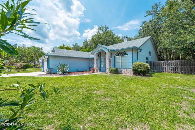 ranch-style house with a garage and a front lawn