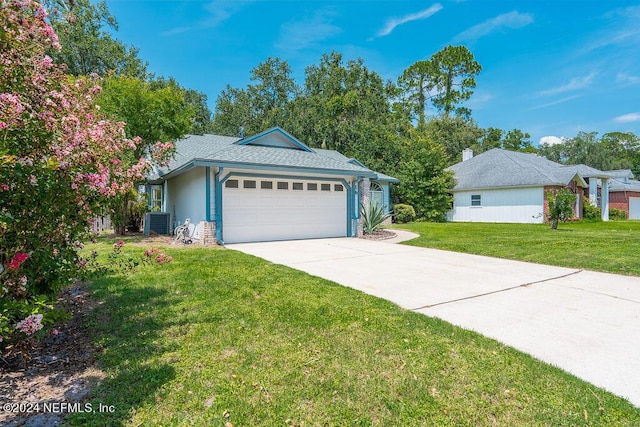 exterior space with an attached garage, central AC, driveway, and a front lawn