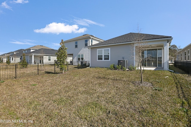 back of house featuring central AC and a yard