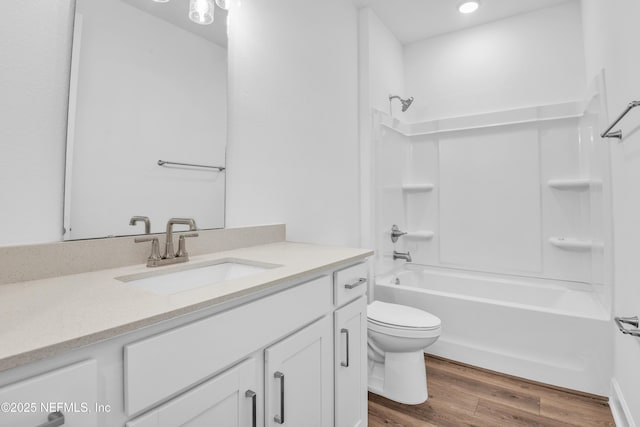 full bathroom featuring wood-type flooring, tub / shower combination, vanity, and toilet