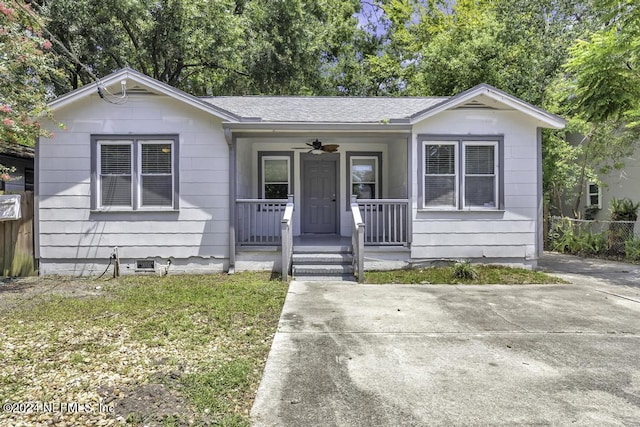 view of front of home with crawl space, covered porch, a shingled roof, and fence